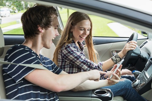 teens looking at phone while driving